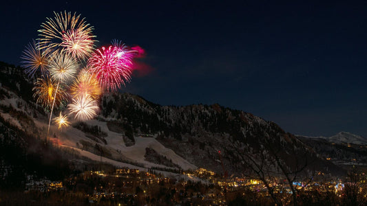 Fireworks set off from a mountainside over the town below.