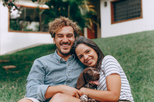 A man and a woman smiling, with a dog